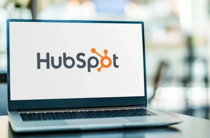 Computadora sobre escritorio con logo de HubSpot